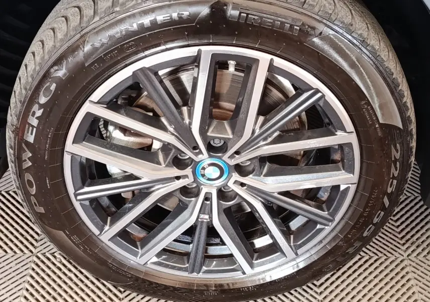 Gros plan sur la jante alliage bicolore et pneu hiver Pirelli du BMW X1 xDrive25e gris foncé.