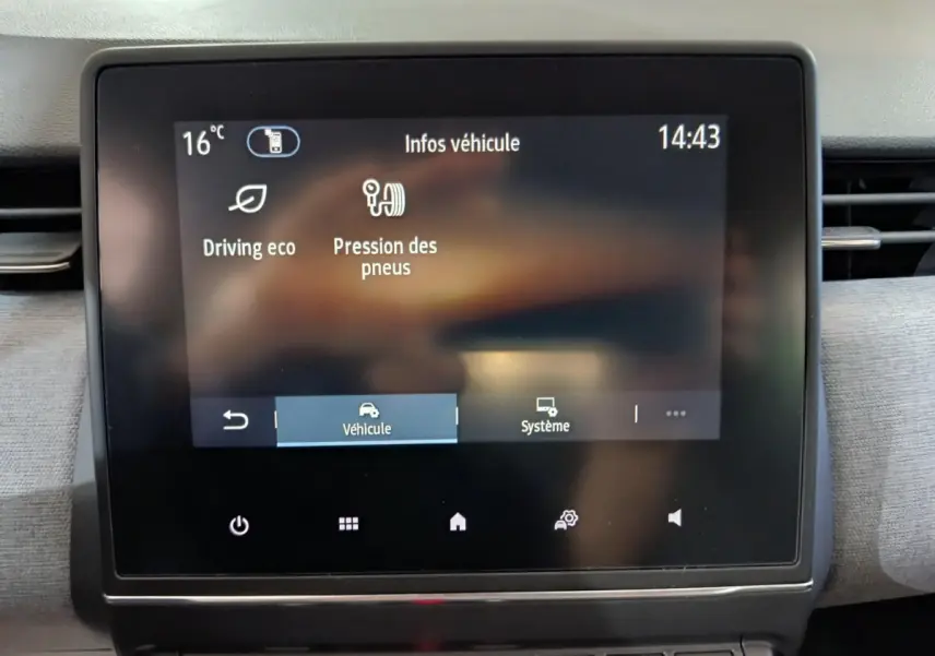 Écran tactile central affichant les infos véhicule dans une Renault Clio gris foncé, vue intérieure frontale.