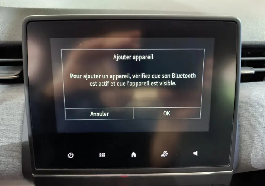Écran tactile central affichant l'ajout d'un appareil Bluetooth dans l'habitacle d'une Renault Clio gris foncé 2025.