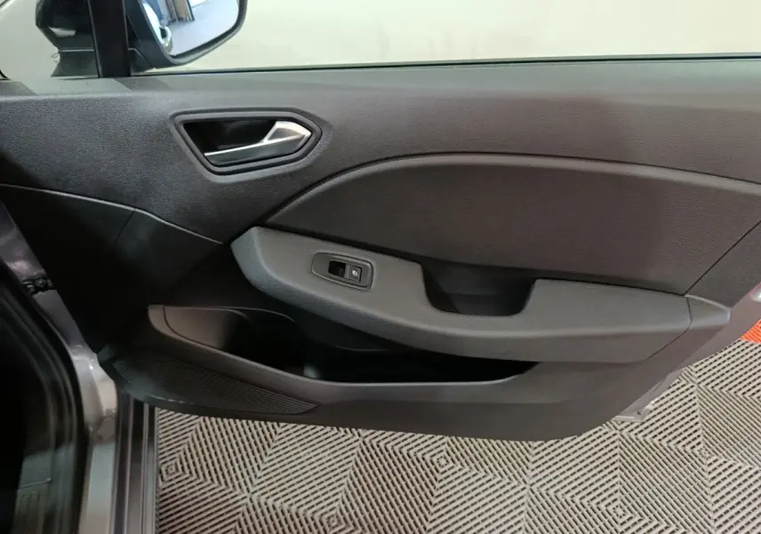 Vue intérieure côté gauche de la porte avant gris foncé de la Renault Clio Evolution Blue dCi 100 avec commande de vitre électrique.