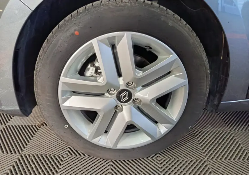 Gros plan sur la roue avant droite grise de la Renault Clio 2025 avec jante alliage à cinq branches épaisses.