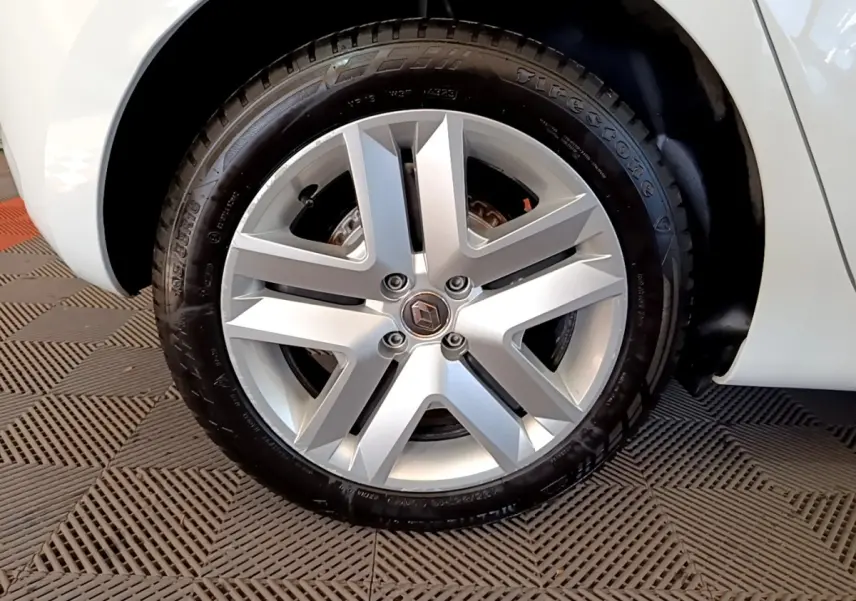 Vue rapprochée de la roue arrière droite d'une Renault Clio blanche, avec passage de roue et partie de la carrosserie visible.