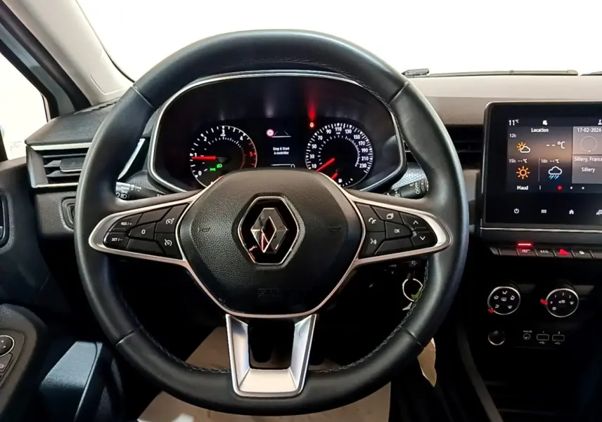 Vue intérieure centrée sur le volant cuir noir de la Renault Clio 2020 avec tableau de bord et écran tactile visible.