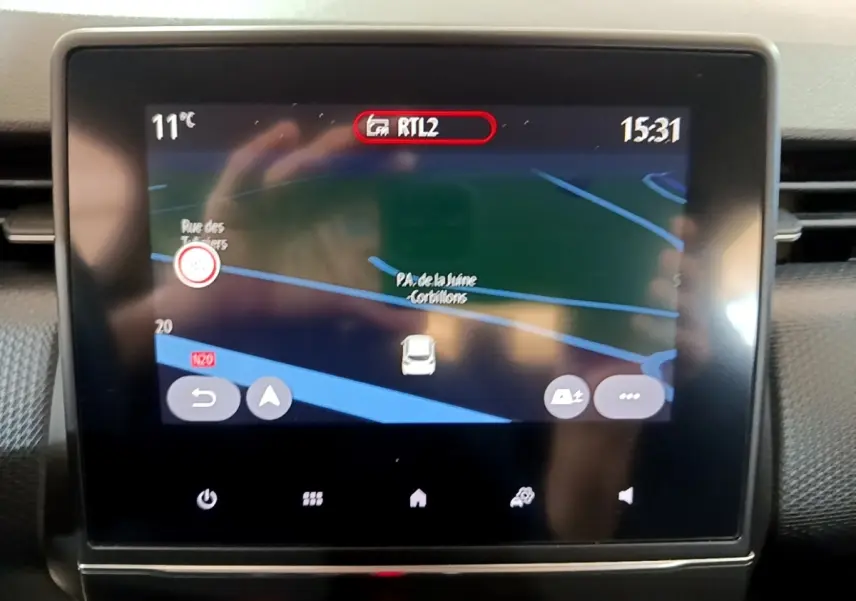 Écran tactile central de navigation 3D dans une Renault Clio Business Blue dCi 115 blanche, vue intérieure frontale.