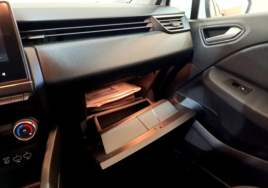 Vue intérieure côté passager de la Renault Clio Business Blue dCi 115 2020, boîte à gants ouverte et tableau de bord noir.