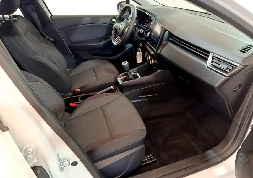 Vue intérieure côté conducteur de la Renault Clio Business Blue dCi 115 blanche, montrant sièges noirs et tableau de bord moderne.