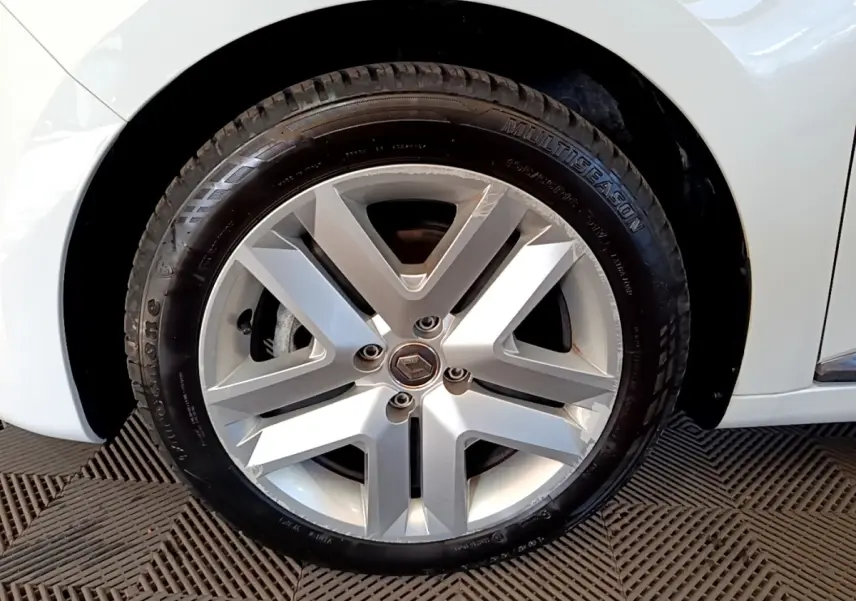 Gros plan sur la roue avant droite de la Renault Clio Business Blue dCi 115 blanche, avec jante alliage et pneu Multiseason.