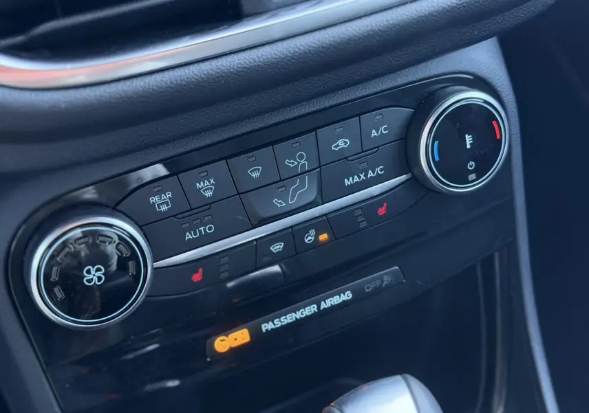 Détail du tableau de bord noir du Ford Puma 2023 montrant les commandes de climatisation automatique et sièges chauffants.