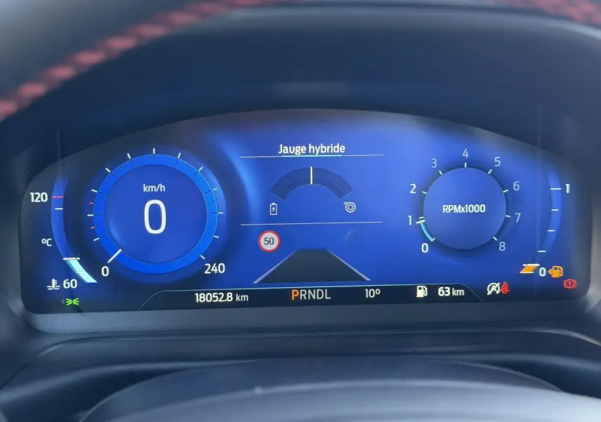 Combiné d'instrumentation numérique bleu du Ford Puma 2023, affichant vitesse, régime moteur et jauge hybride.
