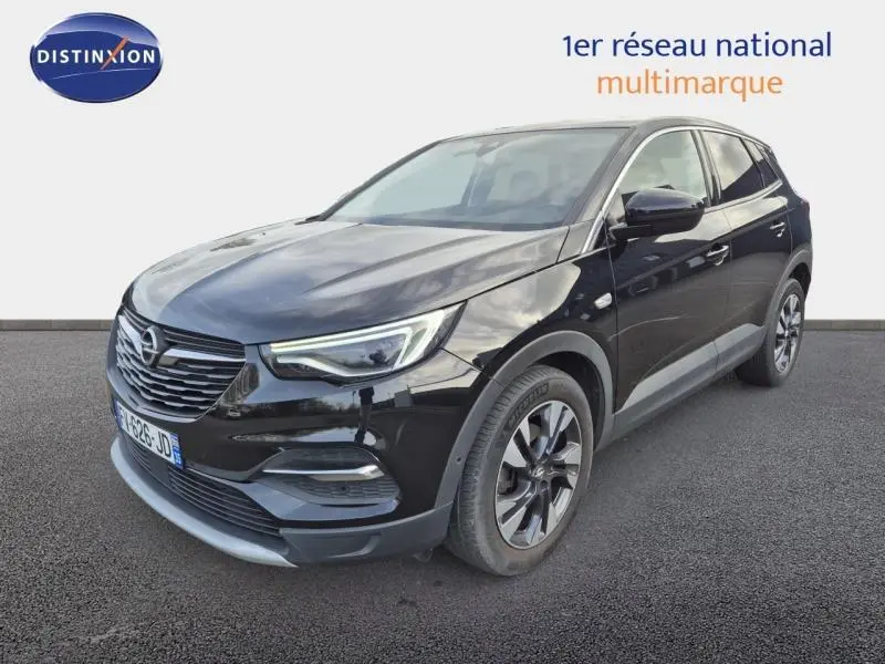 Opel Grandland X noir diamant vu en 3/4 avant droit avec jantes alu et phares LED allumés.