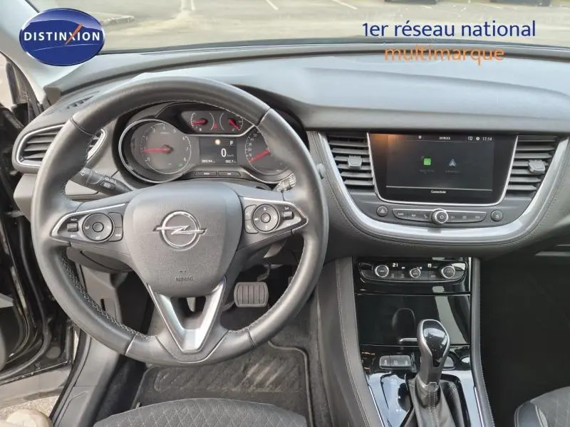 Vue intérieure centrée sur le volant cuir multifonction et la console centrale d'un Opel Grandland X noir diamant de 2020.