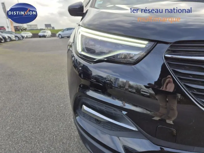 Gros plan sur le phare avant gauche du SUV Opel Grandland X noir diamant, mettant en valeur les LED distinctives.