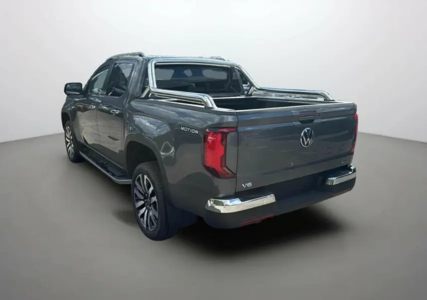 Vue 3/4 arrière droite du Volkswagen Amarok V6 240 BVA10 Aventura gris foncé avec arceaux inox et jantes alu.