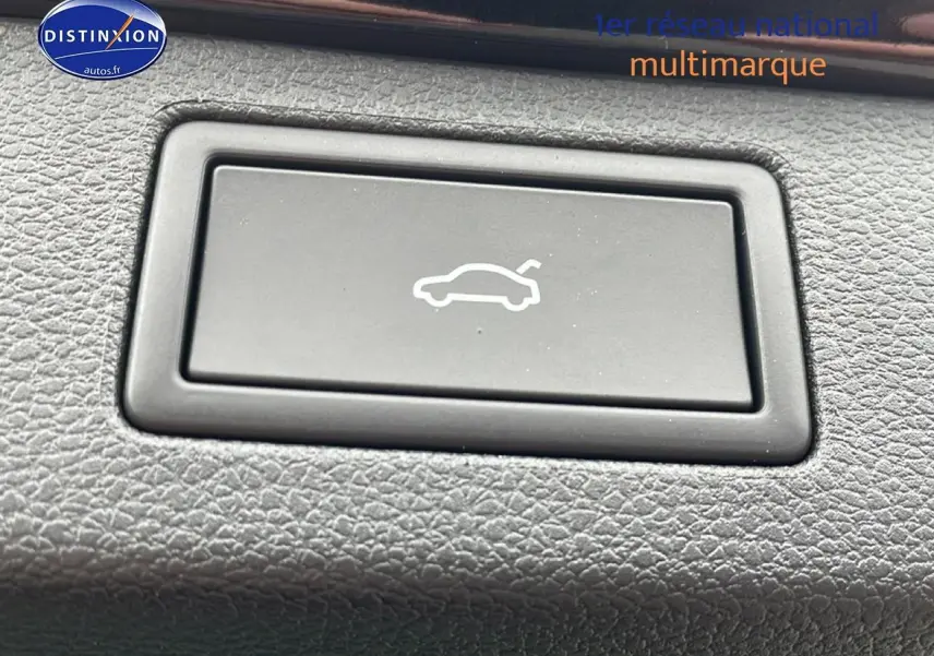 Bouton d'ouverture du hayon sur tableau de bord texturé, intérieur du Skoda Kamiq noir 2026.