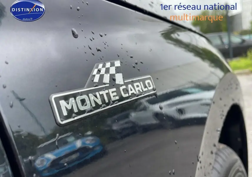 Gros plan sur l'écusson Monte Carlo sur l'aile avant droite d'un Skoda Kamiq noir brillant avec gouttes de pluie.