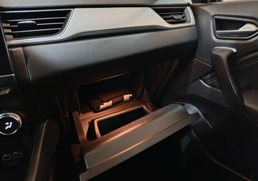 Gant de boîte à gants ouvert côté passager dans l'habitacle noir du Renault Captur Techno TCe 90 2024