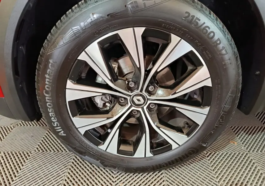 Gros plan sur la jante alliage noire et argentée du côté avant gauche du Renault Captur rouge 2024 Techno TCe 90