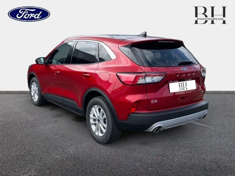 Vue 3/4 arrière droite d'un Ford Kuga 2022 rouge Premium Lucid avec toit panoramique et vitres arrière surteintées.