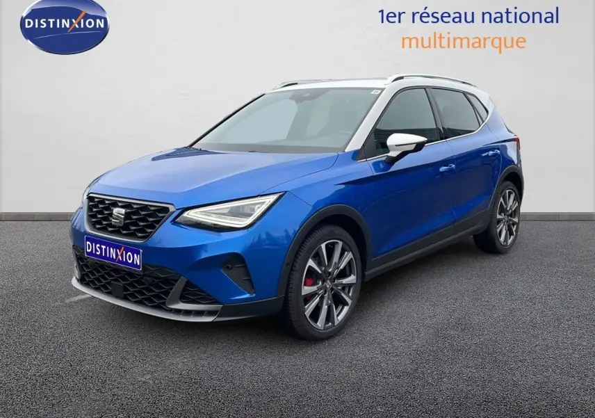 SEAT Arona bleu saphir métal avec toit blanc, vue 3/4 avant droit mettant en valeur ses jantes et calandre sport.