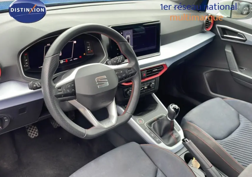 Vue intérieure côté conducteur du SEAT Arona 2025, volant multifonction et levier de vitesse manuelle visibles.