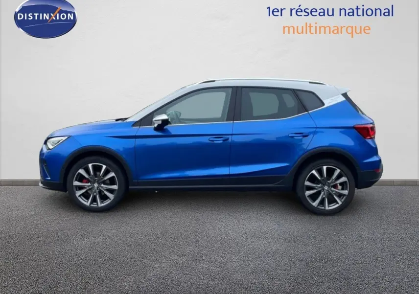 Vue latérale droite d'un SEAT Arona bleu saphir métallisé avec toit blanc, jantes alliage et finitions sport.