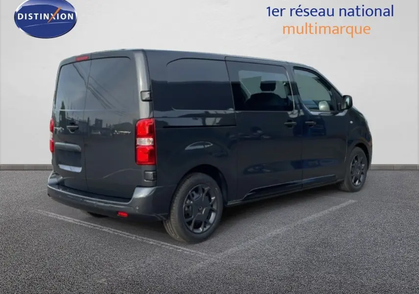 Vue 3/4 arrière droite d'un Citroën Jumpy cabine approfondie gris titane métal avec vitres teintées et jantes noires.