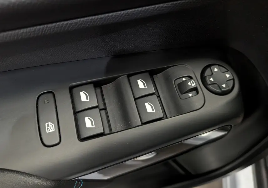 Gros plan sur les commandes de lève-vitres et réglage des rétroviseurs côté conducteur du Citroën C5 Aircross 2025.