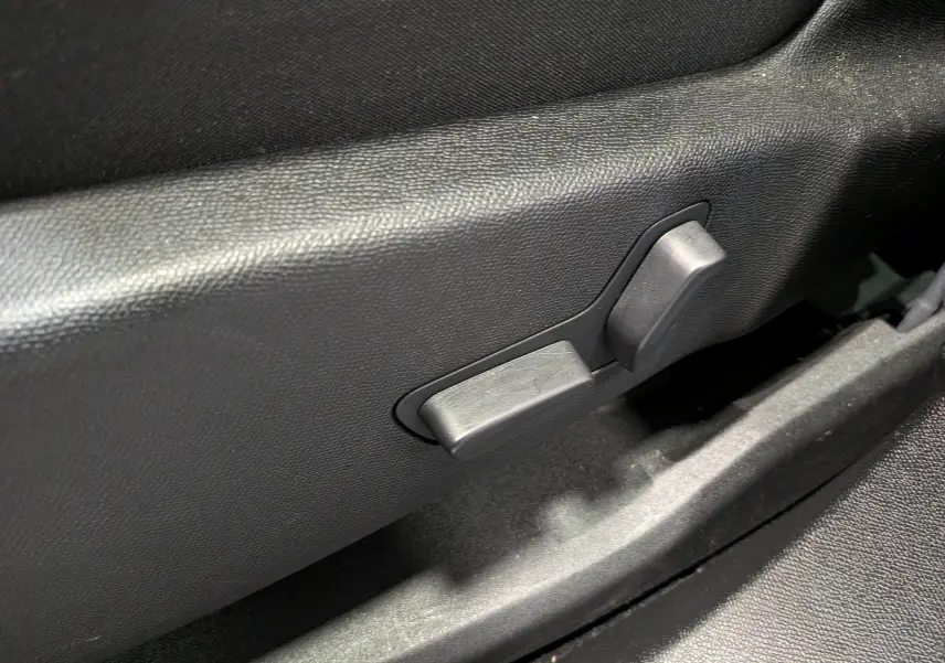 Détail des commandes de réglage manuel du siège en plastique noir dans l'habitacle du Citroën C5 Aircross 2025.