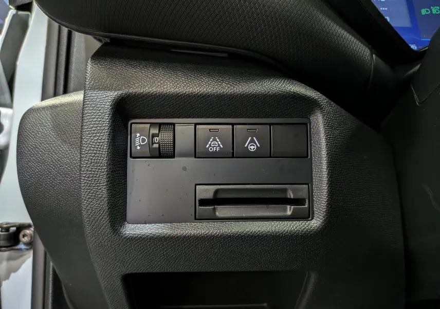 Vue rapprochée des commandes de réglage d’éclairage et d’aide à la conduite sur le côté gauche du tableau de bord d’un Citroën C5 Aircross blanc.