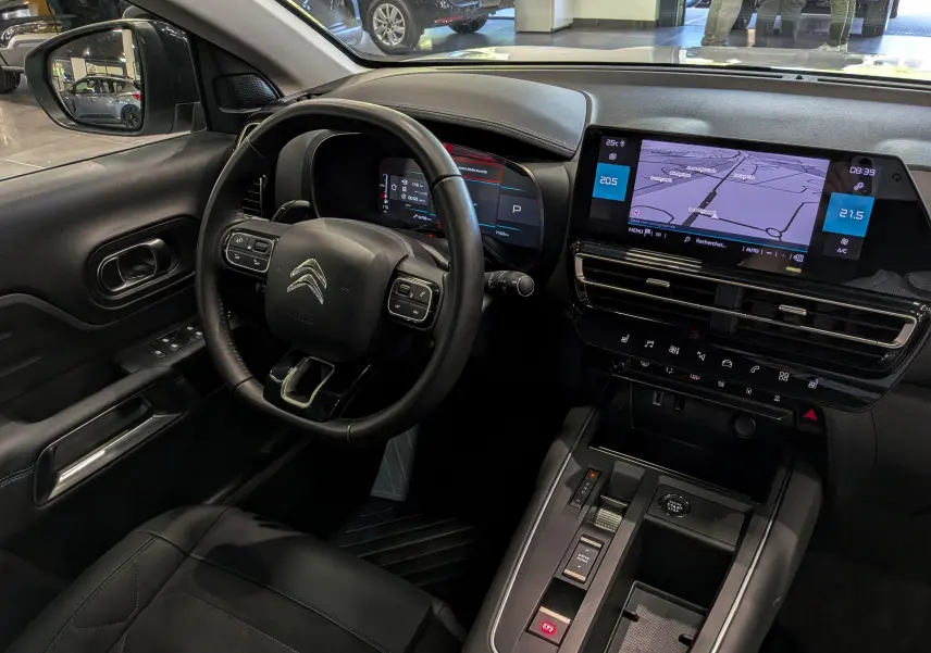 Vue intérieure côté conducteur du Citroën C5 Aircross 2025, tableau de bord avec écran tactile et volant multifonction noir.