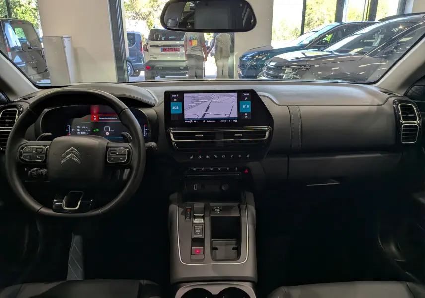 Vue intérieure frontale du tableau de bord du Citroën C5 Aircross 2025, avec écran tactile central et volant multifonction noir.