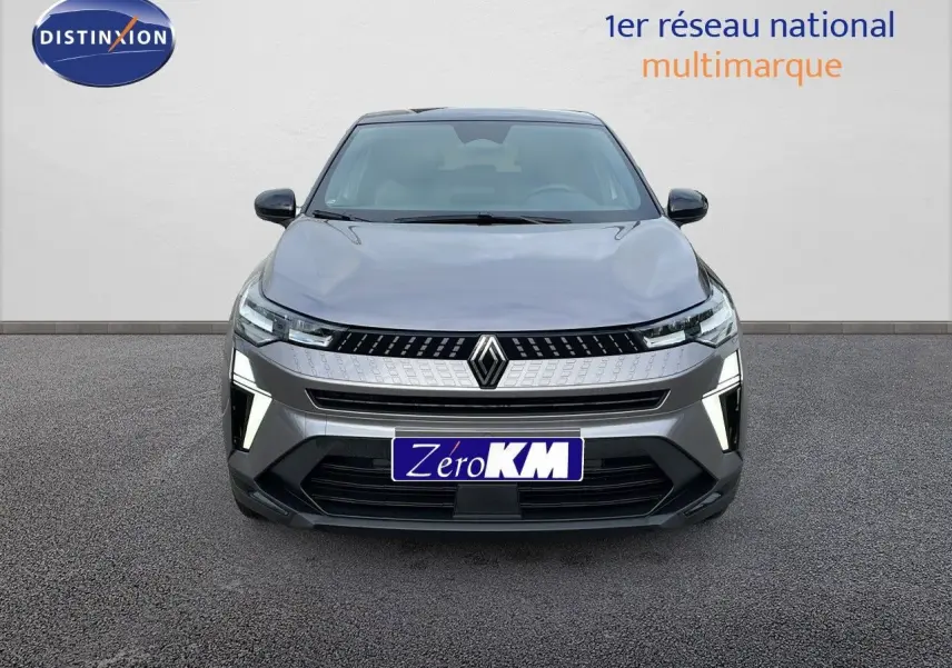 Vue frontale d'un Renault Captur 2025 gris cassiopée métal avec toit noir, éclairage LED distinctif allumé.