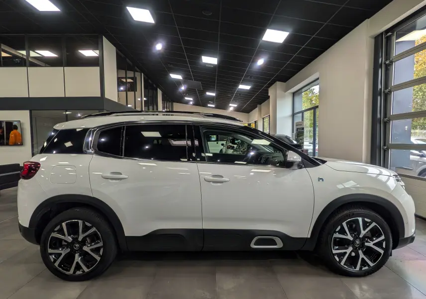 Profil côté gauche du Citroën C5 Aircross hybride rechargeable blanc glacier, avec jantes noires et toit panoramique.