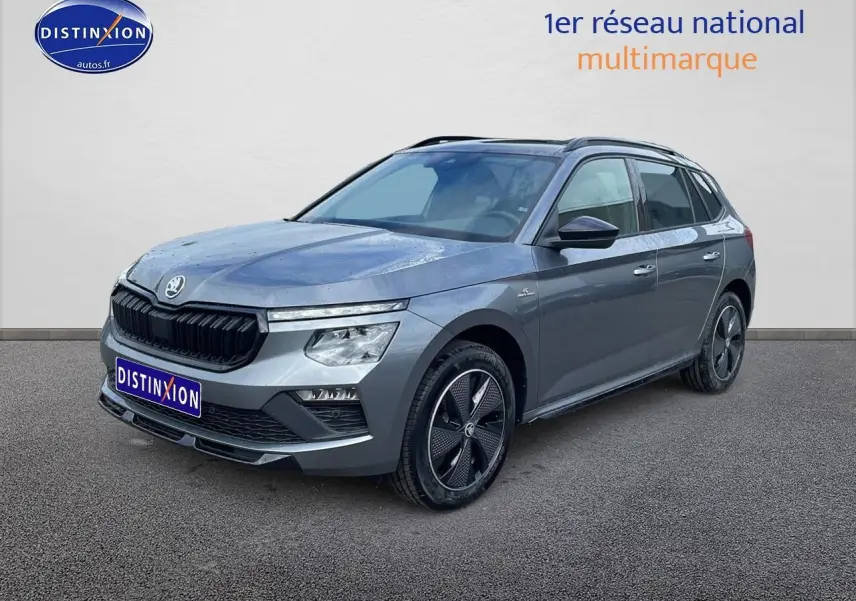 Skoda Kamiq gris graphite en 3/4 avant droit, avec jantes alu noires et toit panoramique en verre.