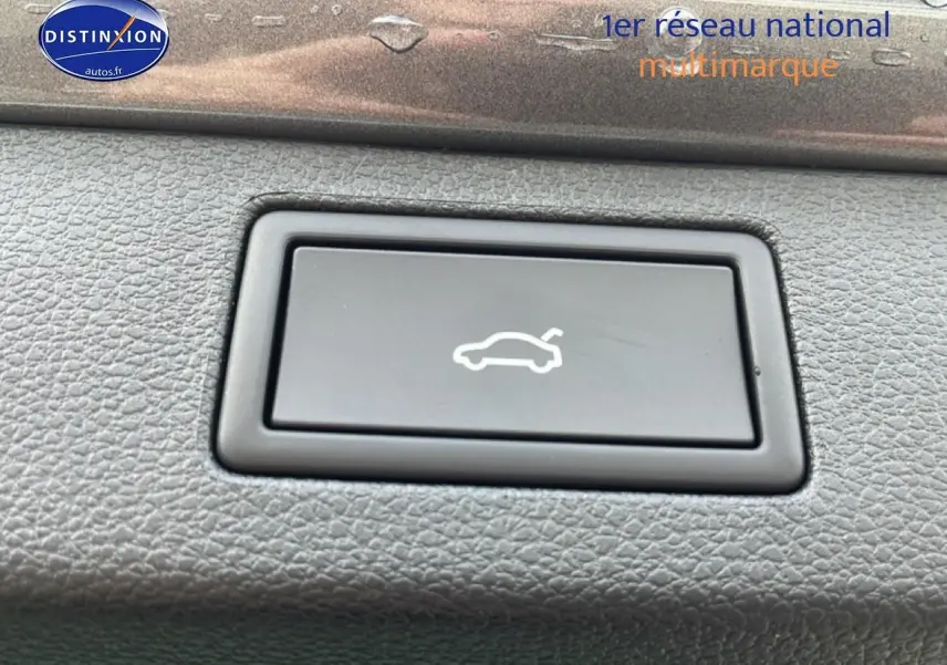 Bouton d'ouverture électrique du hayon sur tableau de bord en plastique gris d'une Skoda Kamiq 2026.