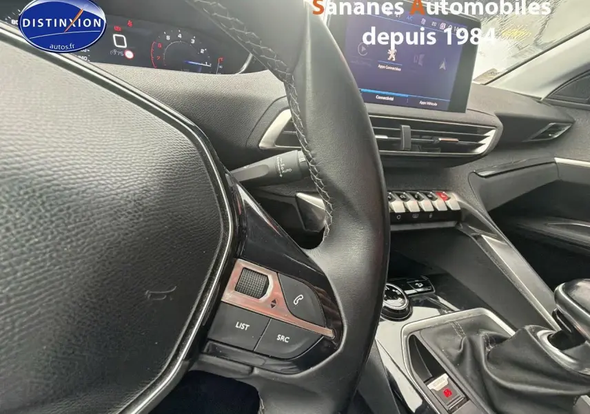 Vue intérieure centrée sur le volant cuir et la console centrale du Peugeot 3008 blanc, avec écran tactile et boîte manuelle.