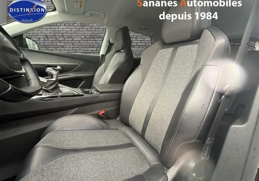 Vue intérieure côté conducteur du siège avant tissu et cuir du Peugeot 3008 blanc 2020 avec levier de vitesse manuel visible.