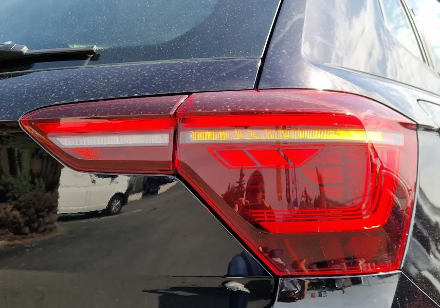 Gros plan sur le feu arrière droit rouge et orange d'une Volkswagen Polo noire de 2022, finition TSI 95.