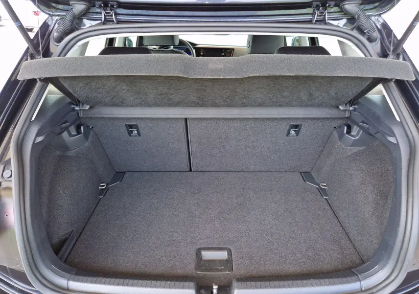 Coffre ouvert vu de l'arrière d'une Volkswagen Polo noire 2022, montrant un espace de chargement propre et vide.