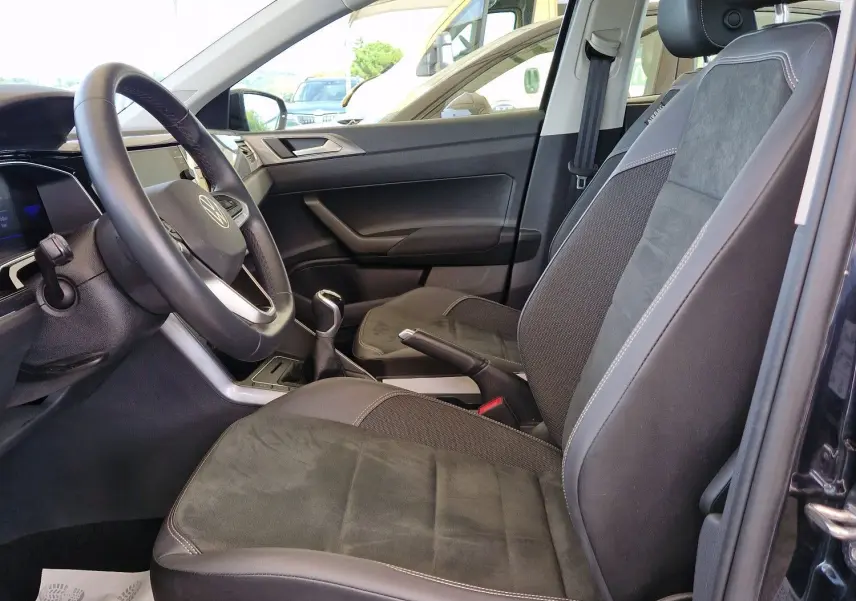 Intérieur côté conducteur de la Volkswagen Polo noire 2022, sièges en tissu et alcantara avec toit ouvrant panoramique visible.