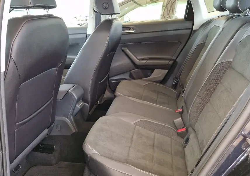 Vue intérieure côté droit des sièges arrière en tissu et cuir gris d'une Volkswagen Polo noire 2022 avec toit ouvrant.