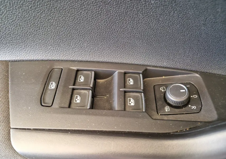 Panneau de commandes des vitres et rétroviseurs côté conducteur d'une Volkswagen Polo noire de 2022.