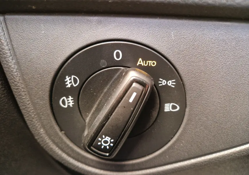 Gros plan sur le sélecteur de phares noir du tableau de bord d'une Volkswagen Polo 2022, avec mode automatique activé.