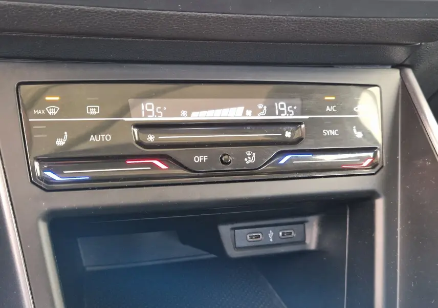 Panneau de climatisation digital de la Volkswagen Polo noire 2022 avec réglages de température à 19,5°C et ports USB visibles.