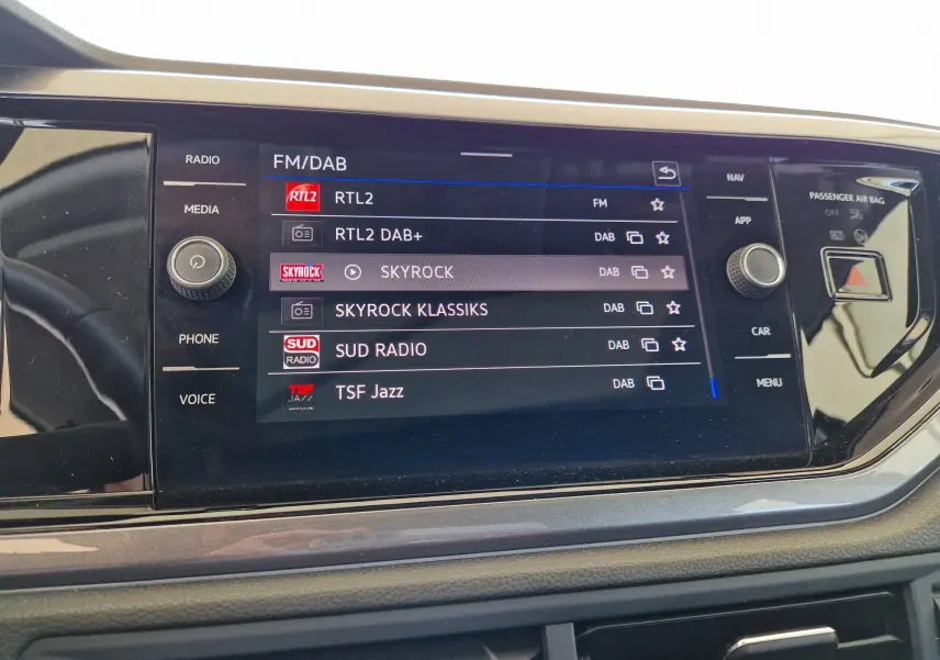 Écran tactile central du tableau de bord de la Volkswagen Polo 2022 affichant les stations radio FM/DAB.