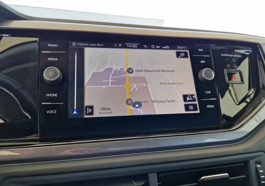 Écran tactile central de la Volkswagen Polo 2022 affichant la navigation avec commandes autour et bouton d'alerte.