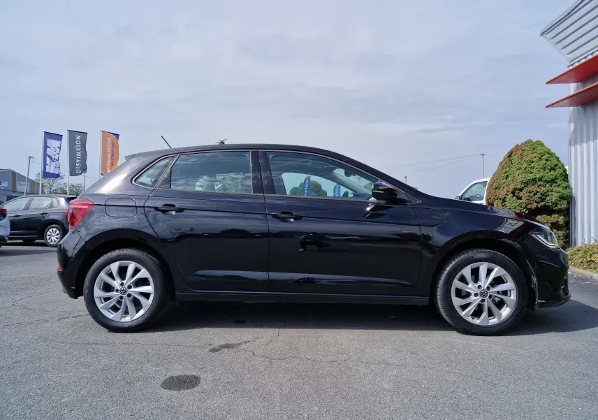 Profil côté gauche d'une Volkswagen Polo noire 2022 avec jantes alliage et carrosserie lisse brillante.