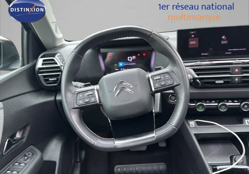 Vue intérieure centrée sur le volant cuir noir et le tableau de bord numérique de la Citroën C4 2021.
