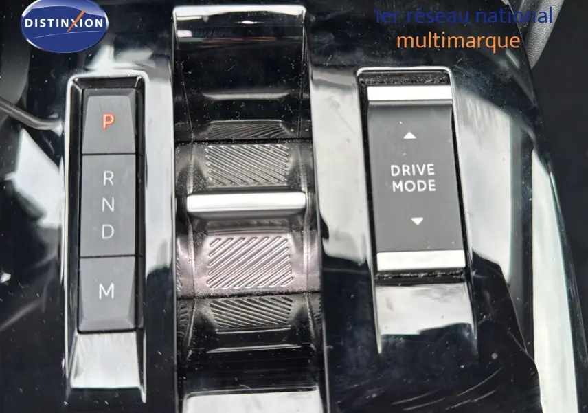 Gros plan sur la console centrale noire brillante avec sélecteur de vitesses automatique et bouton Drive Mode du Citroën C4.