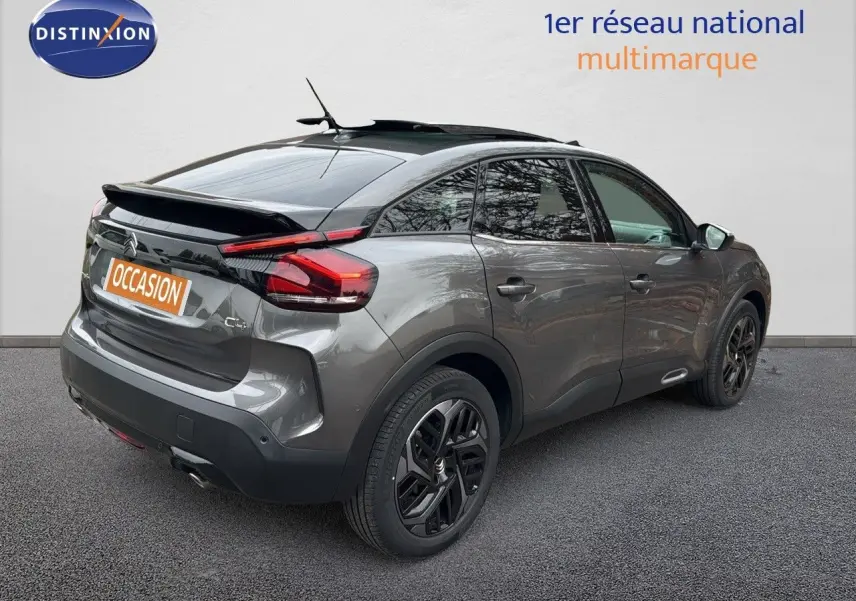Vue 3/4 arrière droite d'une Citroën C4 2021 gris avec toit noir et jantes noires biton, toit ouvrant visible.